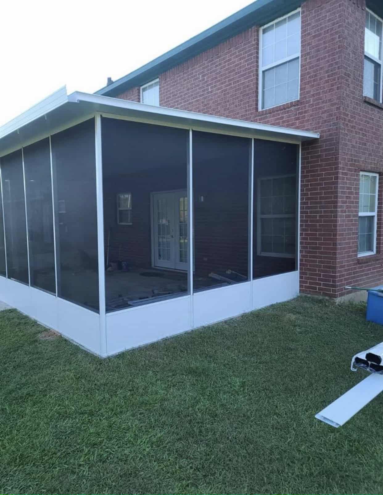 White aluminum screen room on a brick two story home