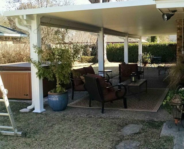 Insulated patio cover with a ceiling fan over an outdoor seating area