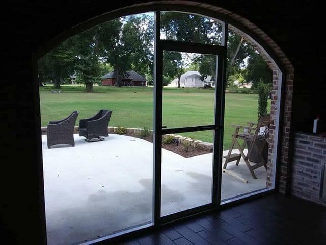 Sliding glass panels opening onto a patio and lawn